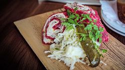  Rohe Roulade aus Celle mit Gurke und Krautsalat auf Holzbrett, regionale Spezialität.