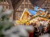 Weihnachtsmarkt in Celle bei Schneefall mit festlich beleuchteten Buden, Fachwerkhäusern und zahlreichen Besuchern in winterlicher Stimmung.