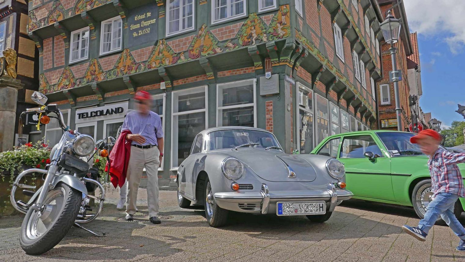 Silbernes Oldtimer-Auto und Motorrad vor dem Hoppener Haus bei der Veranstaltung Oldtimer+Fachwerk in der Celler Altstadt.